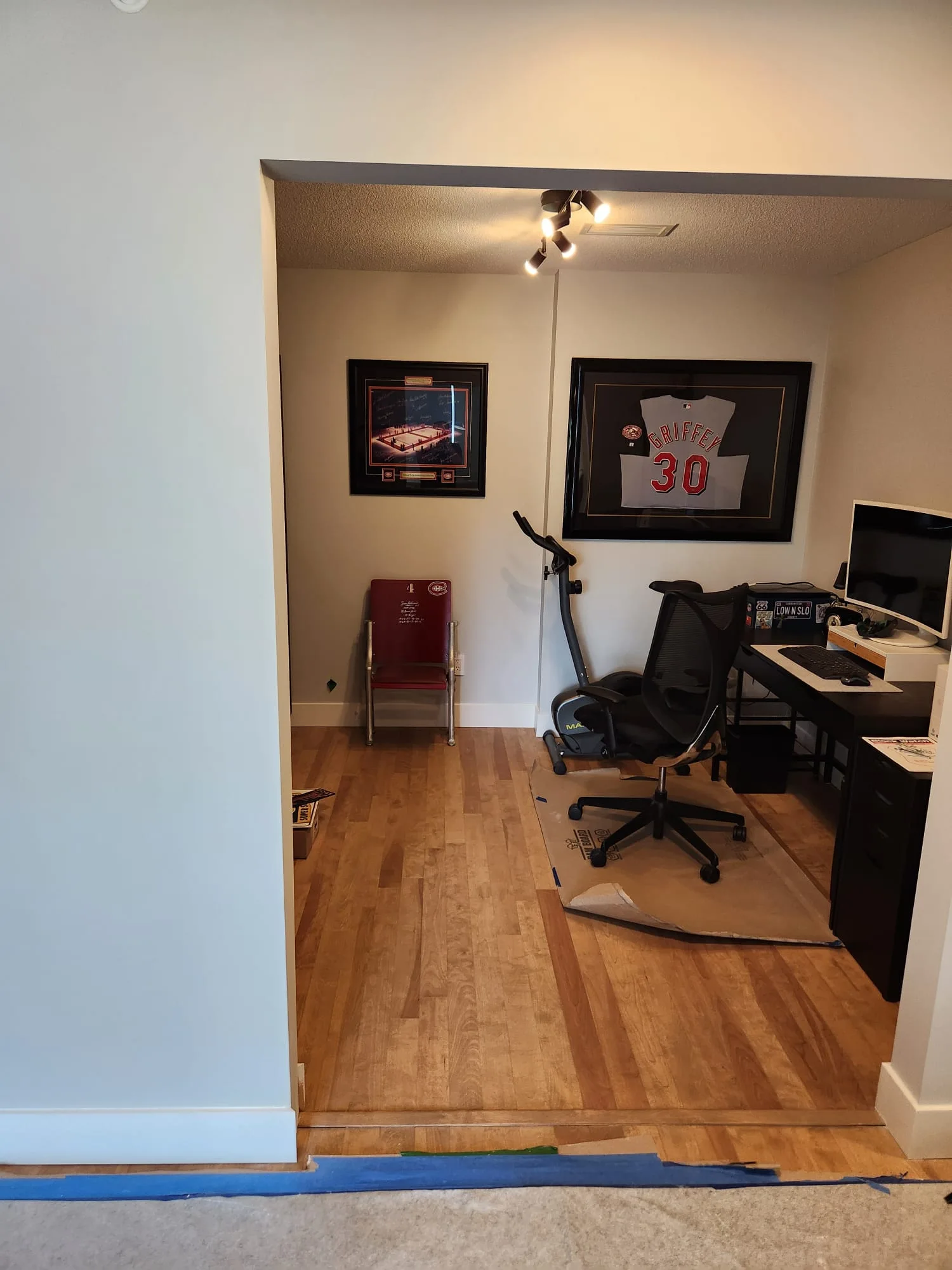 Before installation — view through open doorway into den, Griffey #30 framed jersey and desk visible, no side lite present