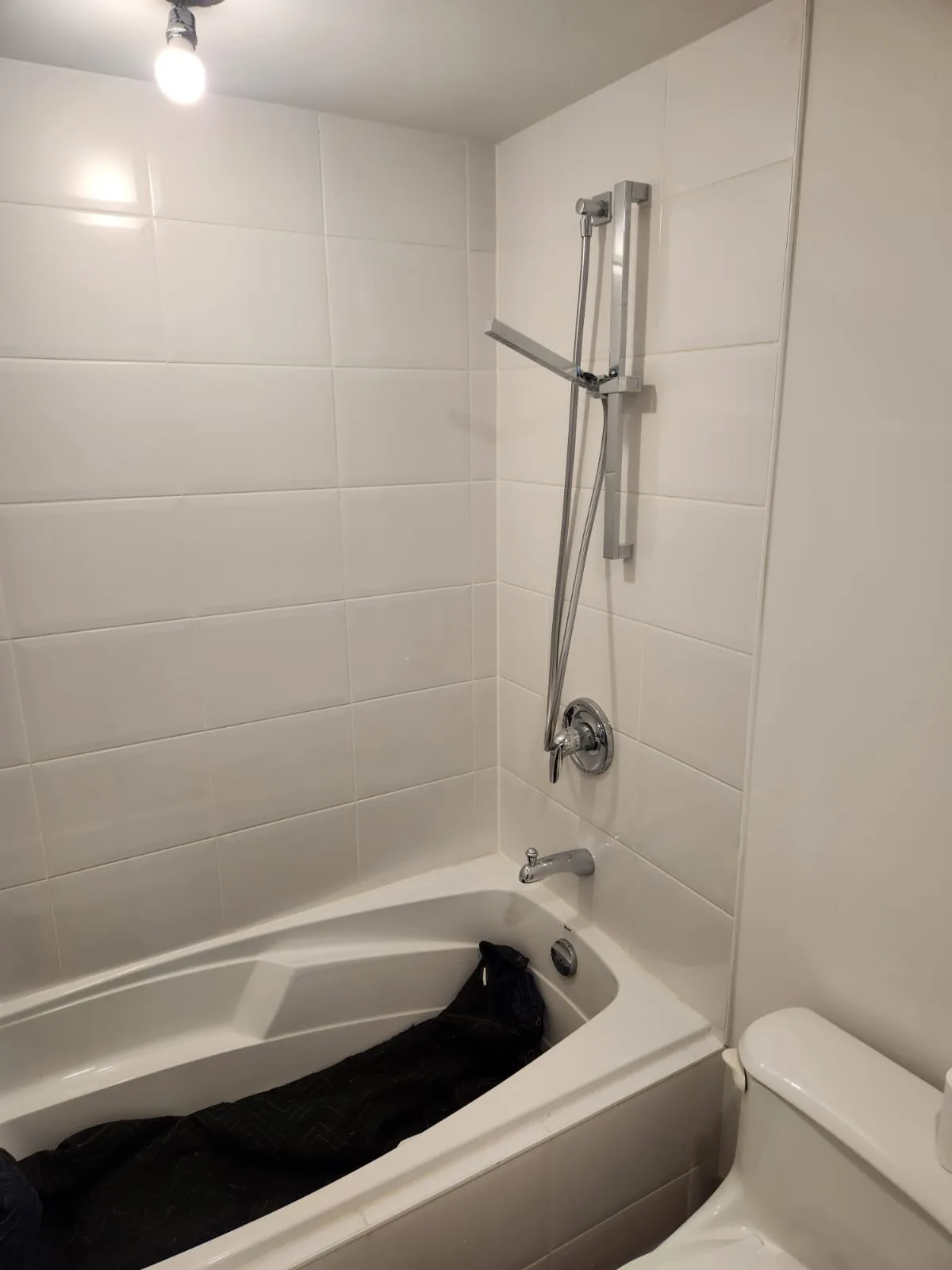 Before installation — soaker tub without glass panel, white subway tile surround