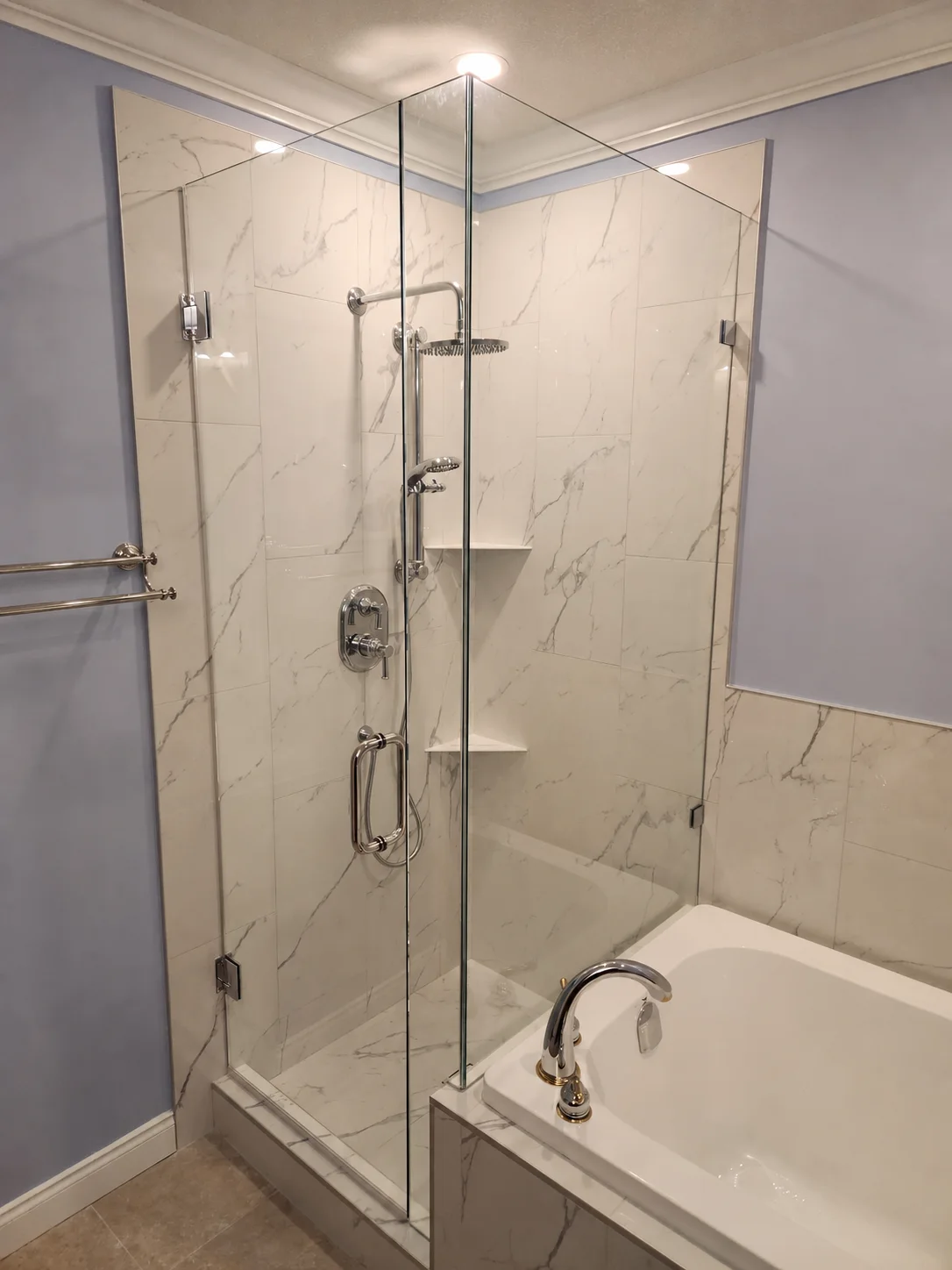 Frameless shower door and fixed return panel — full front view against Calacatta marble tile surround
