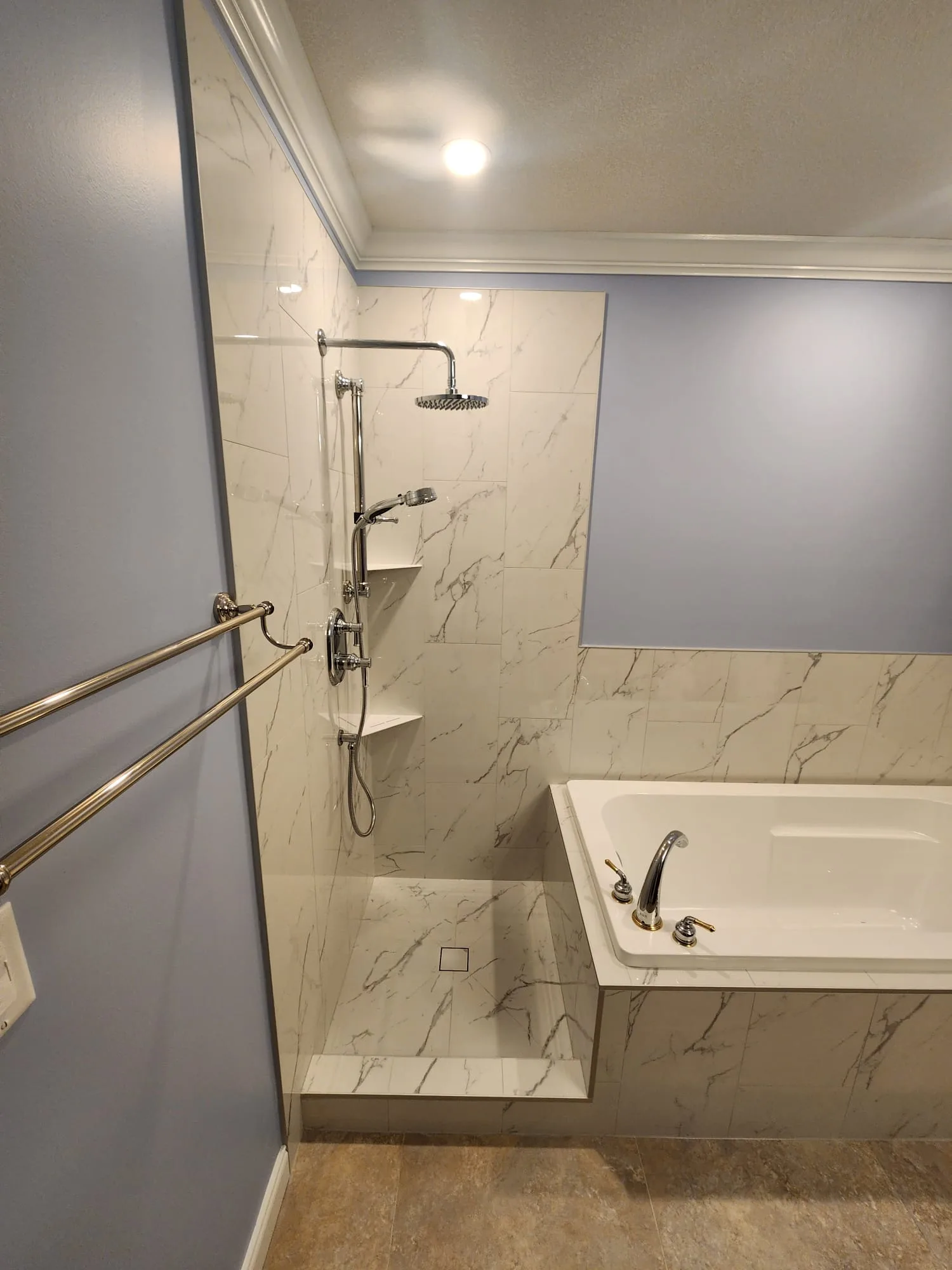 Before installation — shower area with tile and chrome fixtures, no glass enclosure